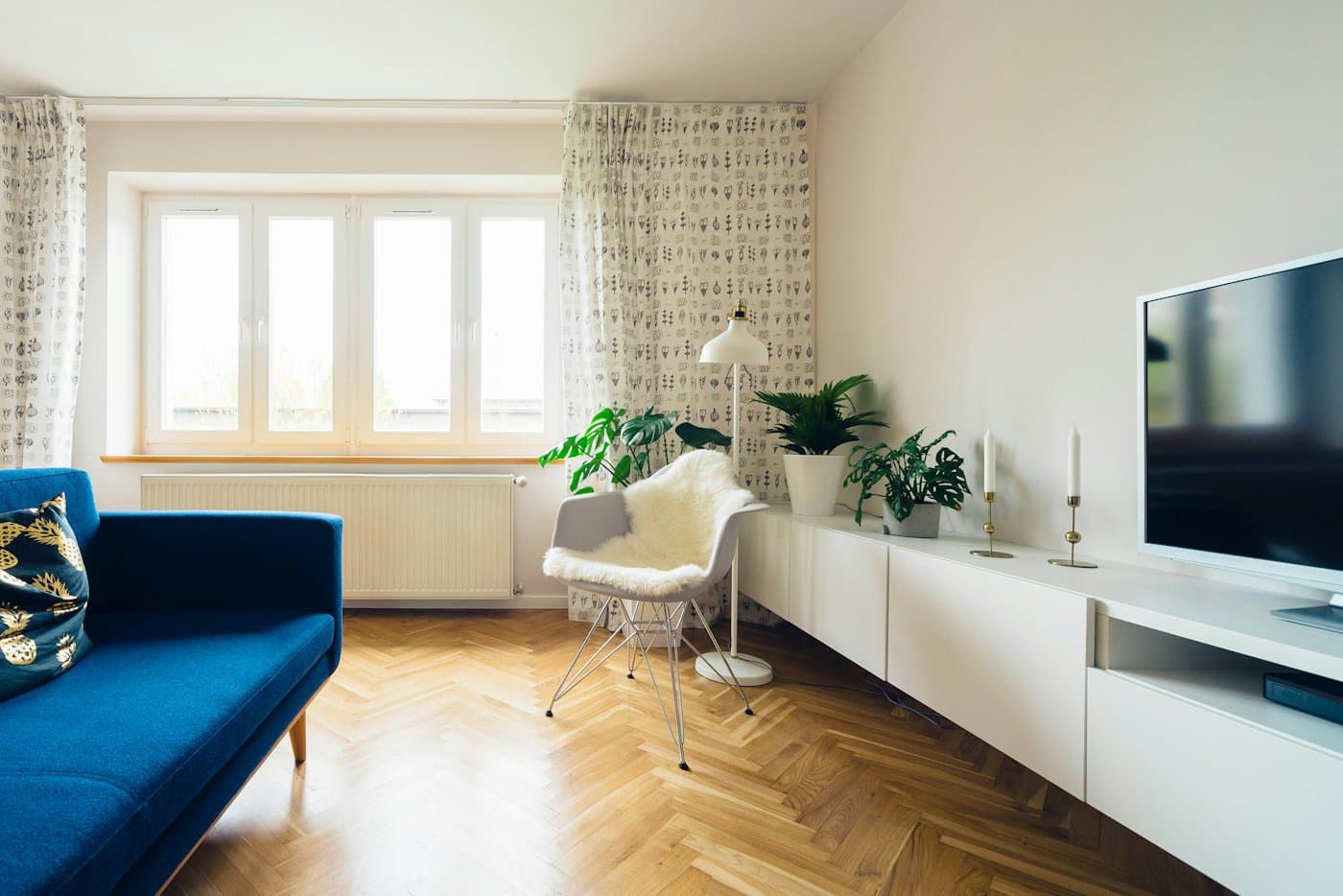 Séjour lumineux, parquet à bâtons rompus et canapé bleu
